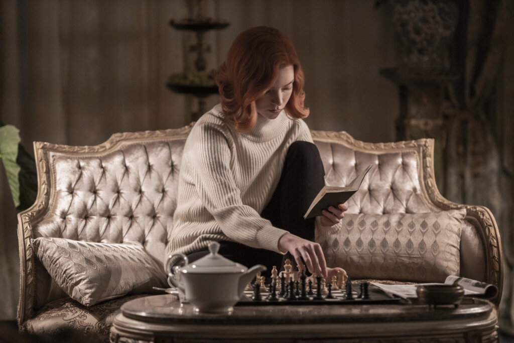 Beth sitting in chair playing chess